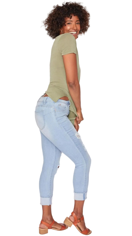 Person wearing a green top and light blue jeans on a white background