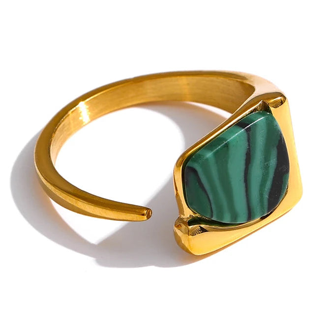 Gold ring with a green stone on a white background