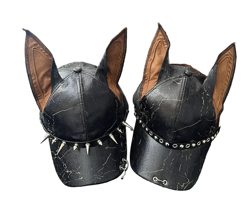 Black leather dog hat with spike details on a wooden surface