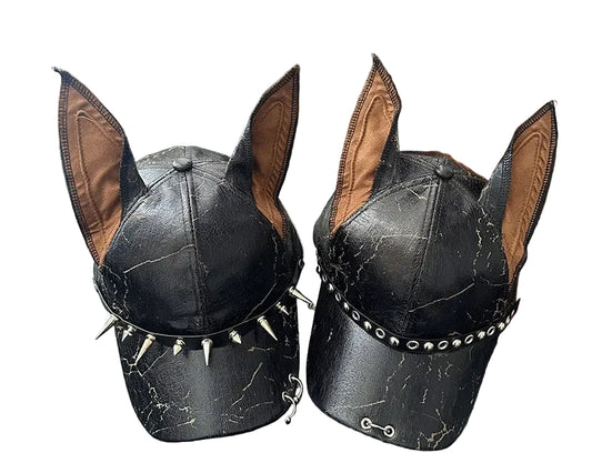Black leather dog hat with spike details on a wooden surface